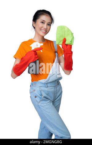 Asian young housewife in protective glove holding bottle sprayer and dry rag isolated over white background Stock Photo