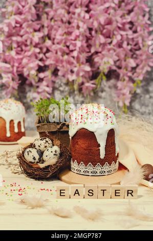cakes, Easter eggs and flowers. with the inscription Easter. the concept of a happy Easter. Vertical Stock Photo