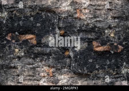 Abandoned burned old brick wall with damaged plaster Stock Photo