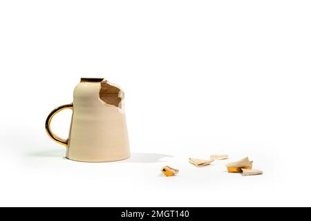 Broken tea cup isolated on white background. Cracked coffee mug and fragile ceramic pieces Stock Photo