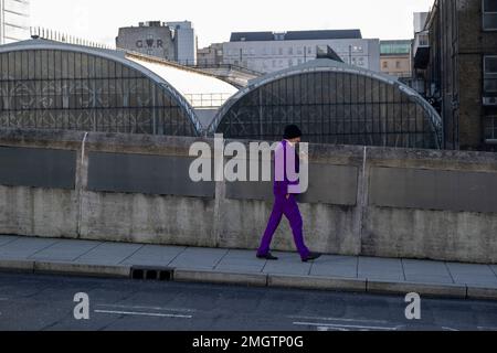 Man wearing a bright purple suit walks past the rear of Paddington Station on 9th January 2023 in London, United Kingdom. Stock Photo