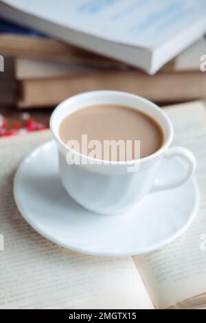 Coffee in a white cup stands on a book, close-up Stock Photo