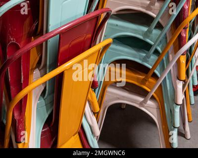 iron stack of multicolored industrial chairs for loft style in fashionable current trends Stock Photo