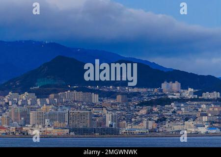 Tarumi, Japan - January 16, 2023: Large Apartment Complexes in Sprawling Coastal City by Mountains Stock Photo