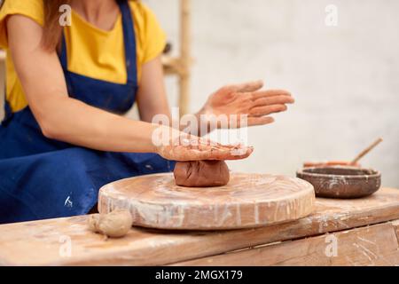 Woman working on potter's wheel. Artisan making clay pot. Workshop of handmade modeling Stock Photo