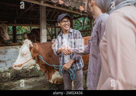 the farmer hand shake with the man that buying his cow Stock Photo