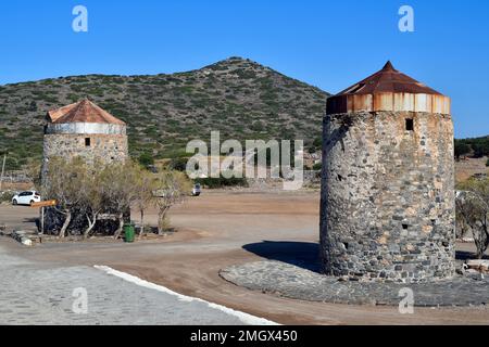 Elounda, Crete,Greece - October 10, 2022: Old windmills built of stone on Kalydon peninsula Stock Photo