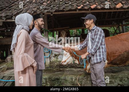 the farmer hand shake with the moslem man that buying his cow Stock Photo