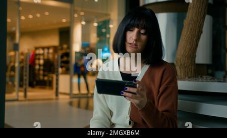 Upset 20s woman girl female gamer lady play with phone video game online playing lost championship failure feel anger annoyance with smartphone Stock Photo