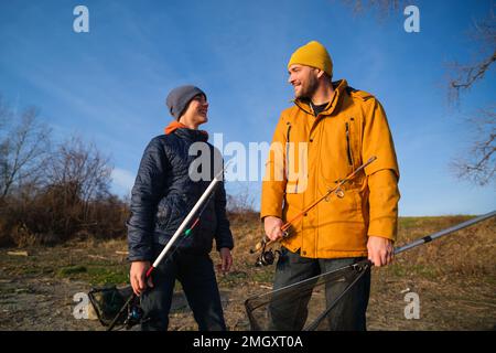 Father and son are fishing on sunny winter day. Freshwater fishing