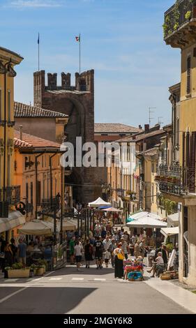 Antiques market in the main street of Soave with Porta Verona city gate in the background in summer, Verona, Veneto, Italy Stock Photo