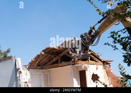 construction industrial site digger yellow demolishing house for reconstruction Stock Photo