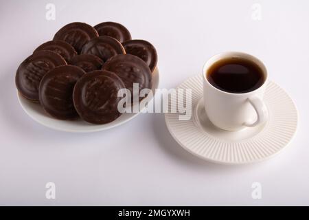 photo of a coffee mug and lots of chocolate chip cookies on a white background Stock Photo