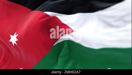 Perspective view of the Jordan national flag waving. Horizontal black, white and green striped flag with red triangle. Fluttering textile. Selective f Stock Photo