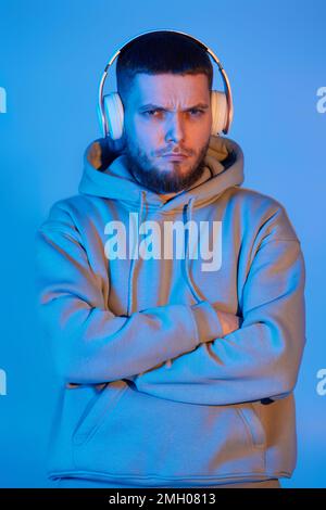 man with headphones in sweatshirt enjoying favorite music Stock Photo