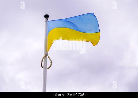flag ukrainian National state flag of Ukraine in yellow blue banner on cloudy dark sky Stock Photo