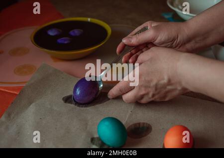 Woman paints Easter eggs for spring holiday Stock Photo