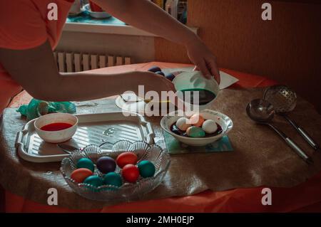 Woman paints Easter eggs for spring holiday Stock Photo