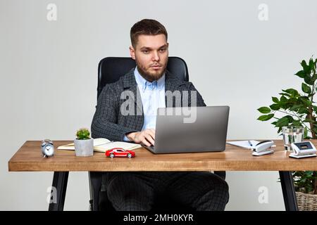 man sitting on chair at table and resting, using laptop Stock Photo