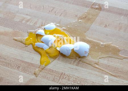 Horizontal shot of a shattered white egg on the floor. Stock Photo