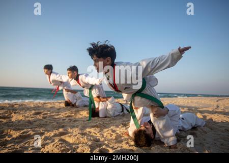 Gaza, Palestine. 26th Jan, 2023. Palestinian youths show off their skills and practice taekwondo on the Mediterranean beach during sunset in Khan Yunis, southern Gaza Strip. (Photo by Yousef Masoud/SOPA Images/Sipa USA) Credit: Sipa USA/Alamy Live News Stock Photo