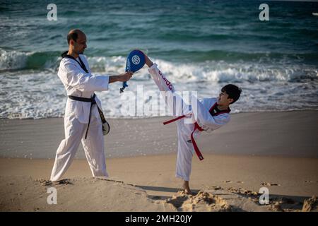 Gaza, Palestine. 26th Jan, 2023. Palestinian youths show off their skills and practice taekwondo on the Mediterranean beach during sunset in Khan Yunis, southern Gaza Strip. (Photo by Yousef Masoud/SOPA Images/Sipa USA) Credit: Sipa USA/Alamy Live News Stock Photo