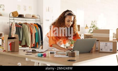 Logistics, laptop and fashion manager of retail or boutique shop checking clothing stock in boxes on a checklist. Small business, entrepreneur and Stock Photo