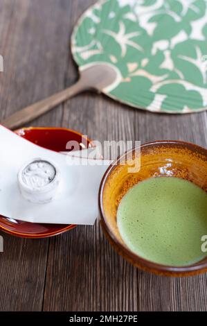 Matcha tea at Taizo-in Temple in Kyoto is served with a traditional sweet depicting a carp fish, and in the summer, a fan. Stock Photo