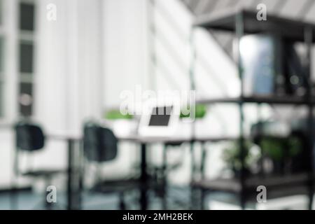 Blurred modern office background with laptops, work desks, chairs. Contemporary coworking, workspace interior. High quality photo Stock Photo
