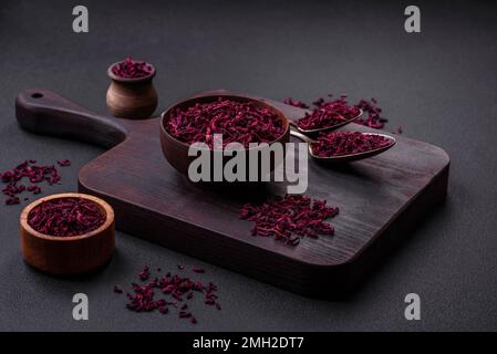 Dried beets in small slices in a wooden bowl on a black concrete background. Asian cuisine Stock Photo