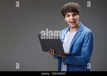 caucasian young man using laptop isolated on gray background Stock Photo