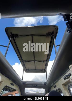 A roof of a convertibles Vintage jeep truck for safari from inside. Uncovered jeep car for safari with umbrella Zanzibar, Tanzania. Stock Photo