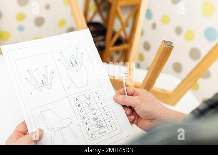 Self-assembly furniture concept. The young man himself assembling chairs Stock Photo