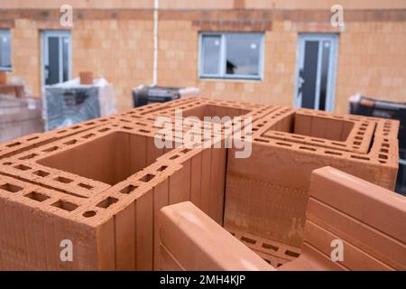 Stack of Red clay Ceramic Thermo Bricks construction material, Work Modular Euro Wall on construction site Stock Photo