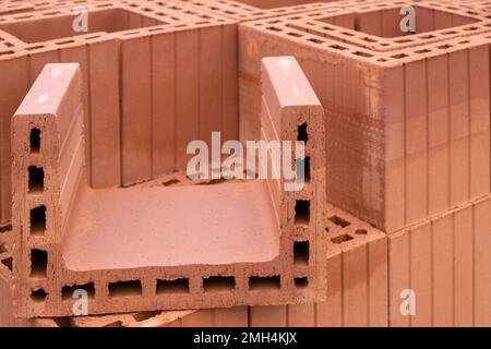 Stack of Red clay Ceramic Thermo Bricks construction material, Work Modular Euro Wall on construction site Stock Photo
