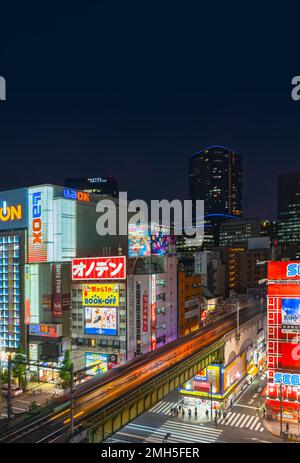 tokyo, japan - august 27 2022: Aerial night view of the Akihabara Crossing Intersection in the electric town crossed by the Sobu line train above the Stock Photo