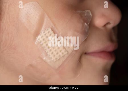 Transparent plaster on kid face macro close up view Stock Photo