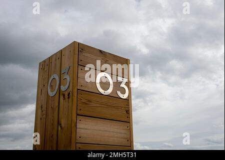 The number three in stainless steel on a wooden background against the sky. 03 Stock Photo