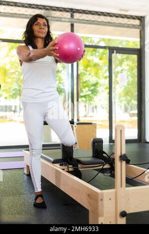 Woman practicing pilates with balls at group class Stock Photo