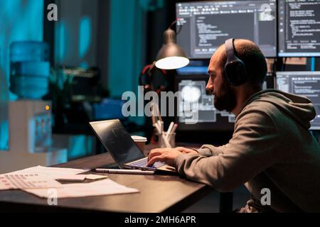 System engineer programming user interface on computer and compiling source code with html script and algorithms. Coding cloud computing online program on multiple screens at night. Stock Photo