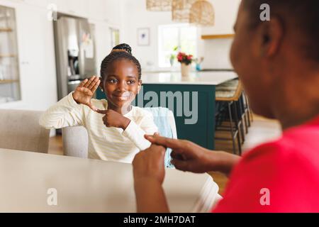 Happy african american grandmother and deaf granddaughter using sign language Stock Photo