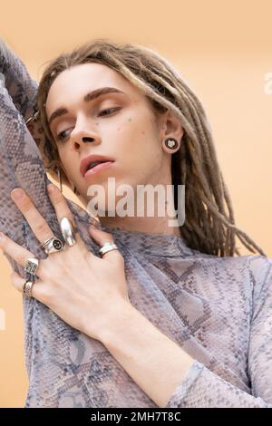 Stylish nonbinary person posing and looking away isolated on yellow,stock image Stock Photo