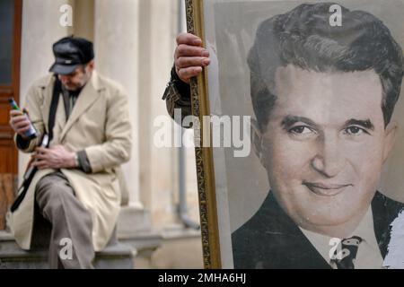 A Man Holds The Official Portrait Of Romanian Communist Dictator ...