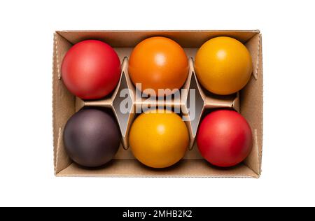Multicolored Easter eggs, Paschal eggs, in a egg carton. Hard boiled, colorful dyed chicken eggs, used to celebrate the resurrection of Jesus. Stock Photo