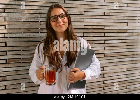 Attractive young woman with laptop computer and cup of tea Stock Photo