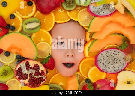 Vitamins from fruits. Mix of fruits near kids face. Assorted mix of summer fresh fruits. Healthy nutrition for kids. Stock Photo