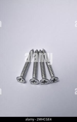 Close-up on screws, metal screws, iron screws, isolated on whited background. Flat Head Stock Photo