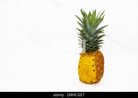 pineapple with half peeled peel on white background Stock Photo