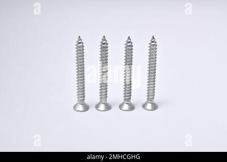 Close-up on screws, metal screws, iron screws, isolated on whited background. Flat Head Stock Photo