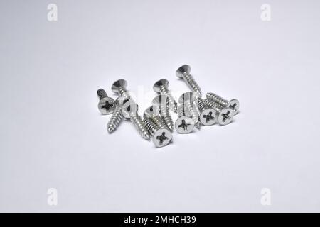 Close-up on screws, metal screws, iron screws, isolated on whited background. Flat Head Stock Photo